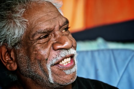 Portrait of a male Aboriginal elder with grey hair smiling