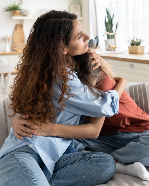 Mum comforts daughter on couch-1